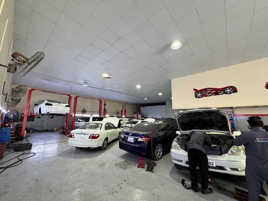 Technicians working on vehicles inside Al Sulaiman Garage